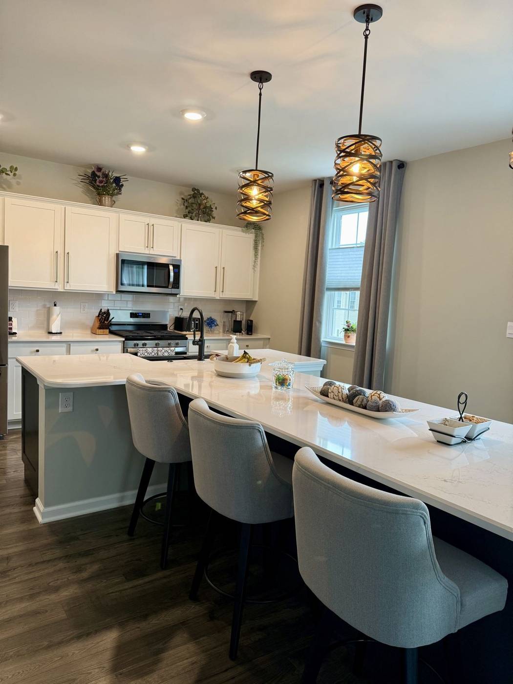 Clean residential kitchen with a long island and bar stools