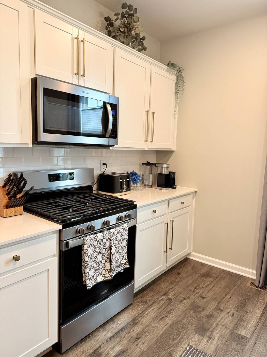 Fresh white kitchen with a clean stove and microwave