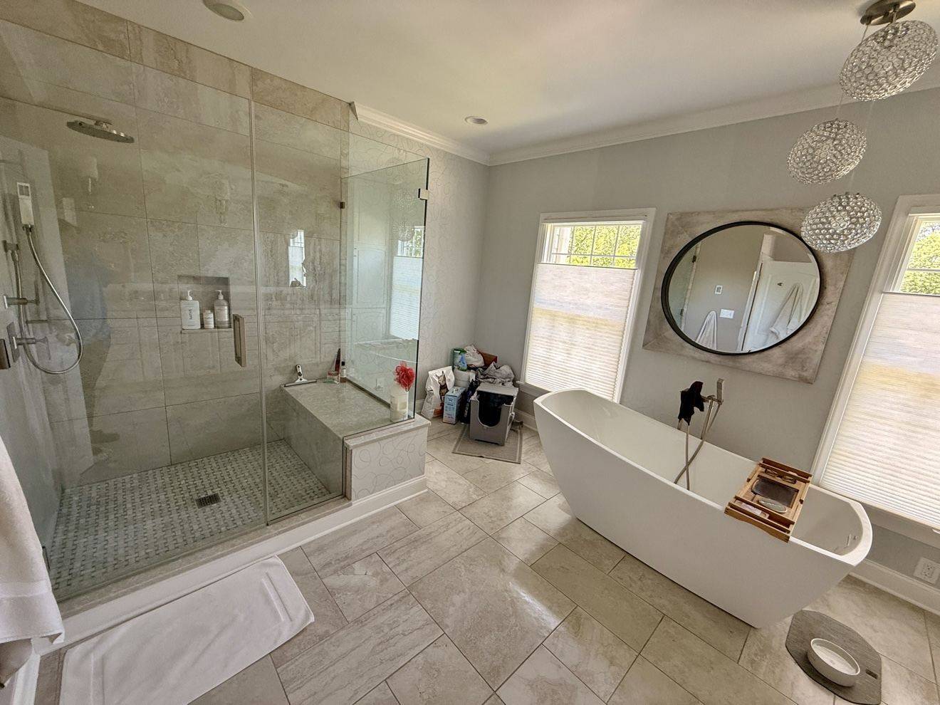 Polished primary bathroom with a glass shower and freestanding tub