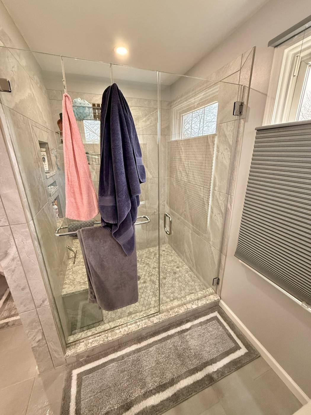 Polished glass shower enclosure in a white bathroom