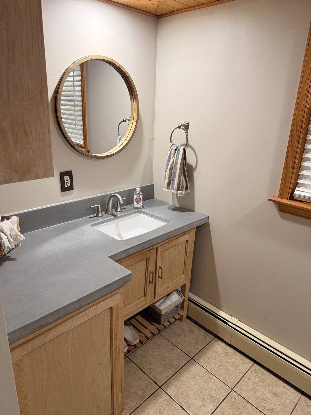 Clean cabin bathroom vanity with a round mirror