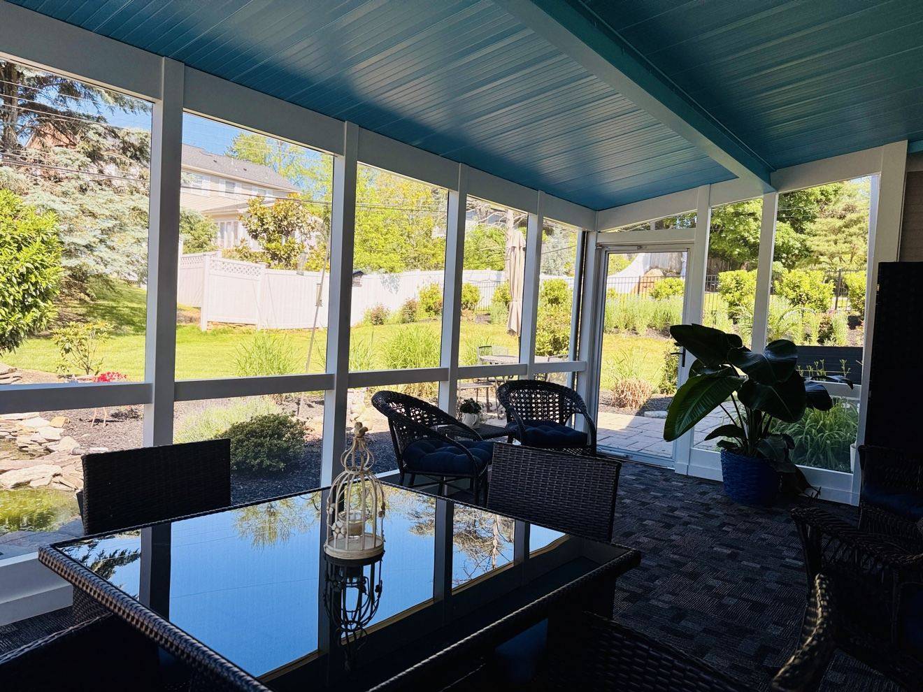 Clean screened porch with a gleaming glass table