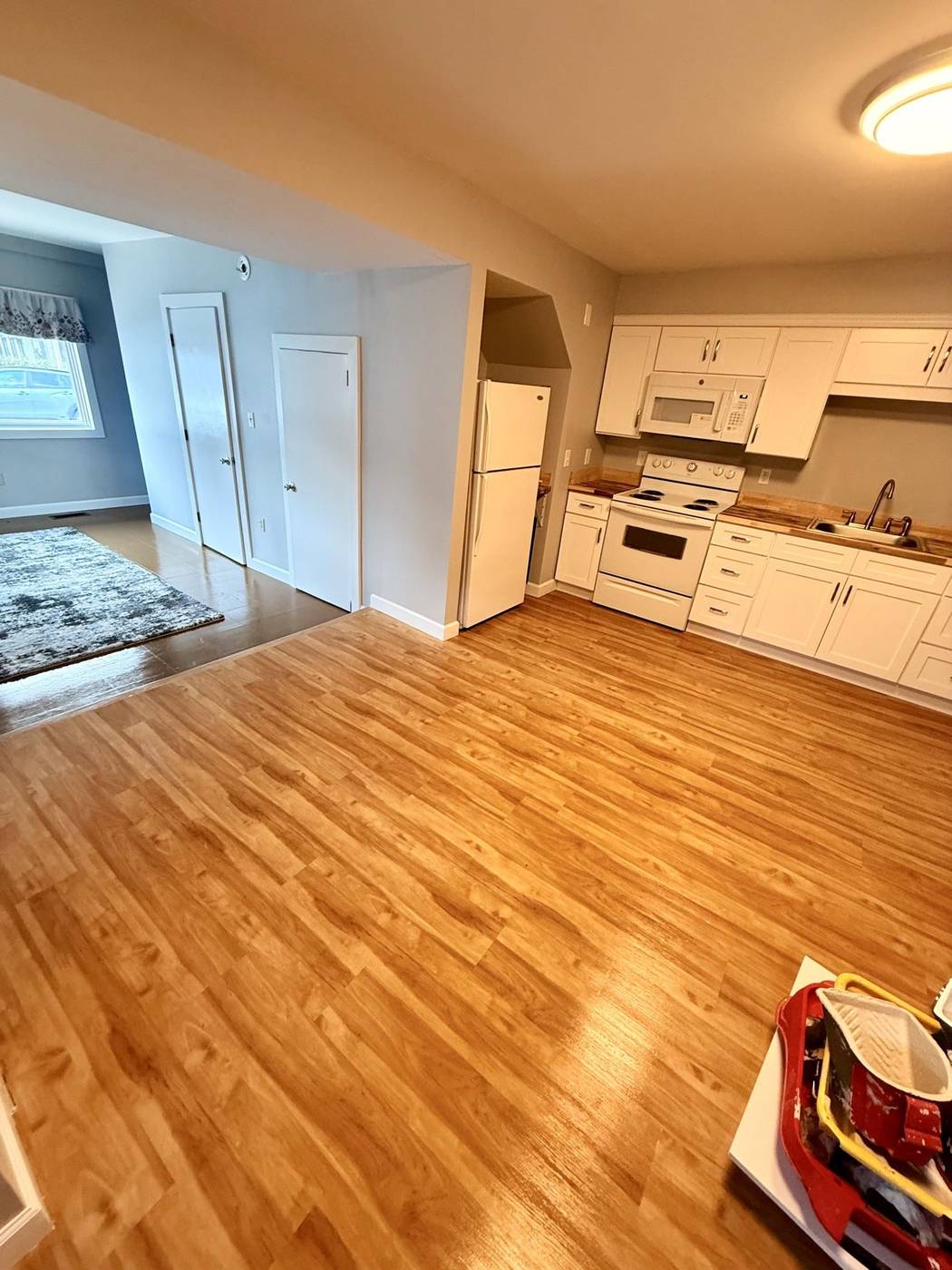 Clean apartment kitchen and living area with polished wood floors
